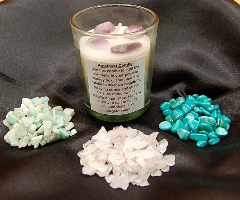 candle with amethyst crystals next to 3 piles of crystals