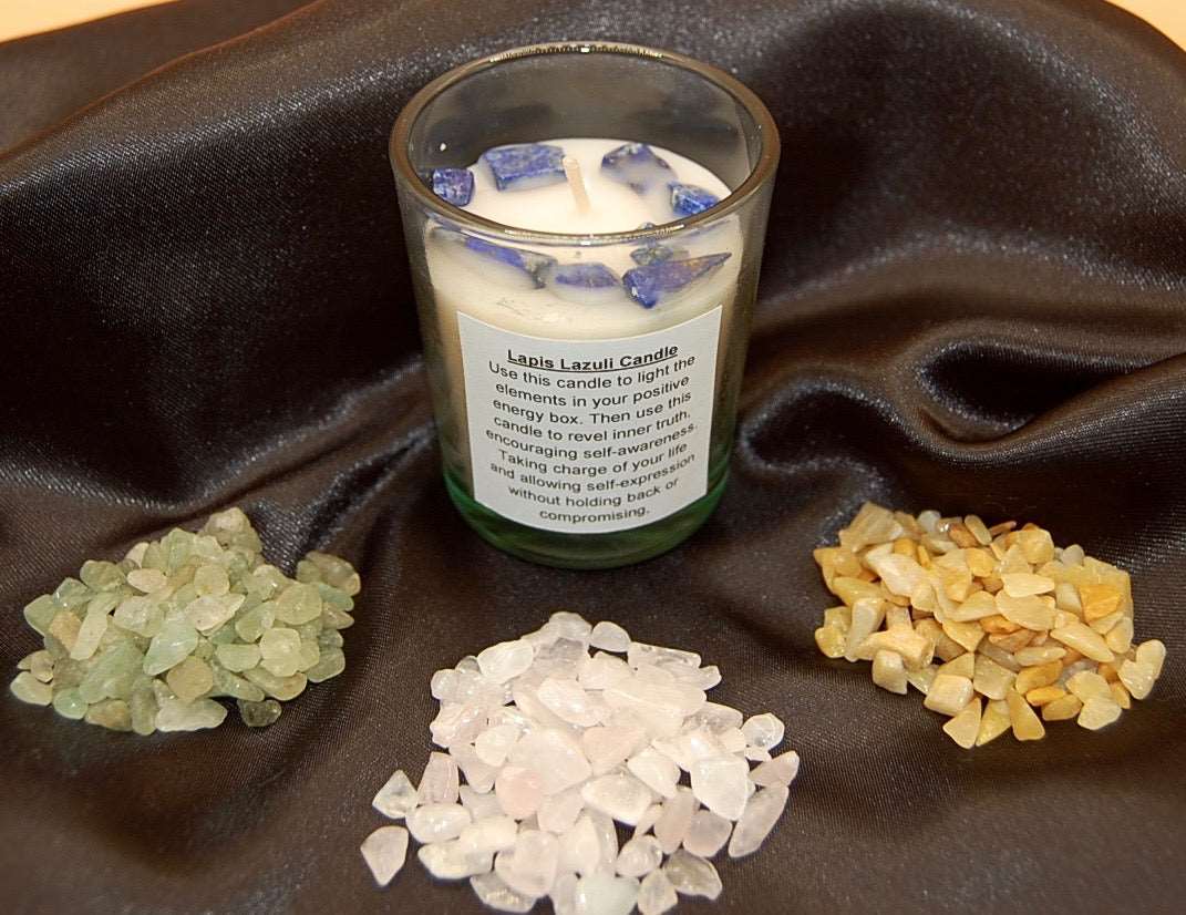 Lapis Lazuli crystals in a candle with piles of crystals on a black silk napkin